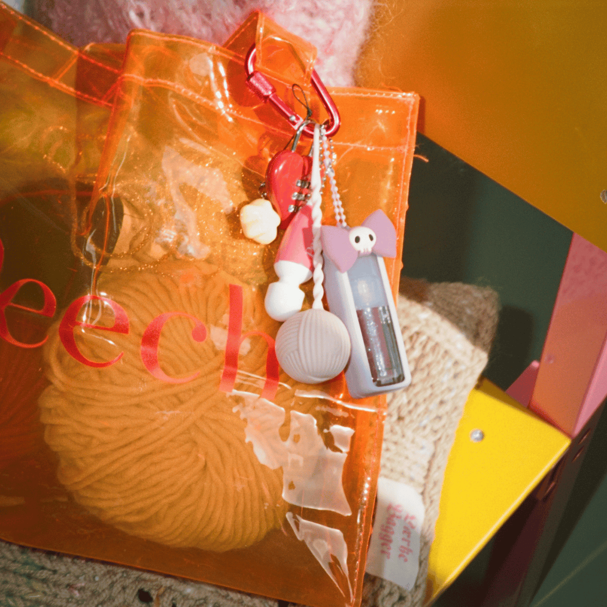 Pink yarn-shaped vibrator hanging from an orange bag